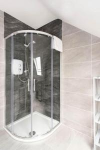 y baño con ducha y mampara de cristal. en Modern newly refurbished house 10 minute walk from Lahinch en Lahinch