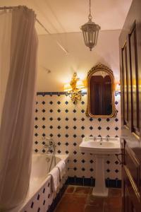 La salle de bains est pourvue d'une baignoire, d'un lavabo et d'un miroir. dans l'établissement Hotel Rural Casa dos Viscondes da Varzea, à Lamego