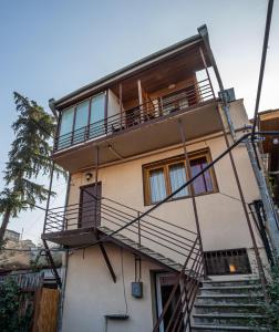 an apartment building with stairs and a balcony at Hotel Old Tbilisi 5 rooms in Tbilisi City
