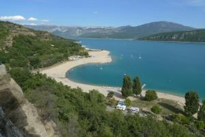 una vista di una spiaggia con barche in acqua di Lou Marcelou - Apartment Two a Sainte-Croix-de-Verdon