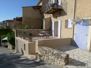 un edificio con un muro in pietra e un balcone di Lou Marcelou - Apartment Two a Sainte-Croix-de-Verdon