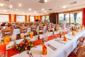 a large banquet room with white tables and chairs at Landgasthof 'Zur Quelle' in Wächtersbach