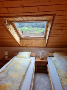 2 camas en una habitación con ventana en Dachwohnung in Welschenrohr, en Welschenrohr