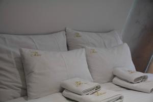 a white couch with white pillows and towels on it at Miletic Villas in Despotovac