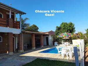 a villa with a swimming pool and a house at Chácara Vicente Gazzi in Socorro