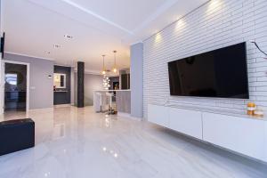 een woonkamer met een grote televisie aan een bakstenen muur bij Luxury 2 bedroom apartment in Los Cristianos in Los Cristianos