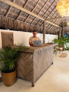a man sitting at a desk with a laptop at Ronco do Mar Jeri in Jericoacoara