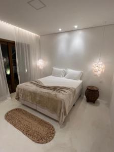 a white bedroom with a large bed and a rug at Beco do Mar Jeri in Jericoacoara +54 photos