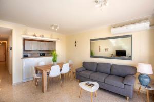 - un salon avec un canapé et une table dans l'établissement 1011 Piso Lago San Maurici con piscina y jardín, à Empuriabrava