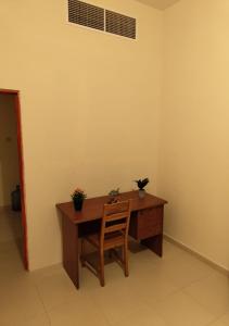 a wooden desk with a chair in a room at Private Room In shared apartment in heart of Ajman in Ajman 