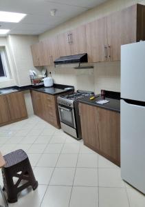 an empty kitchen with a stove and a refrigerator at Private Room In shared apartment in heart of Ajman in Ajman 
