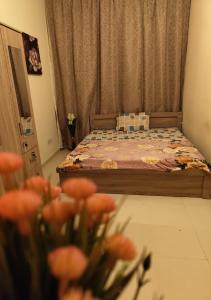 a bedroom with a bed with flowers in the foreground at Private Room In shared apartment in heart of Ajman in Ajman 