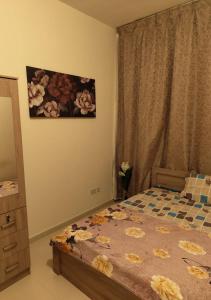 ein Schlafzimmer mit einem Bett und einem Wandgemälde in der Unterkunft Private Room In shared apartment in heart of Ajman in Ajman 