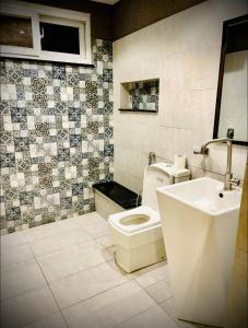 a bathroom with a toilet and a sink at 12th Avenue in Lahore +10 photos