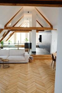 a living room with a white couch and wooden floors at Trautesheim Ferienwohnungen in Wangen im Allgäu