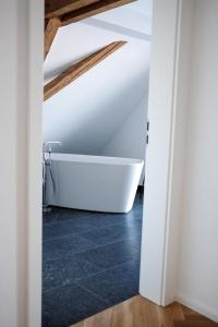 La salle de bains mansardée est pourvue d'une baignoire. dans l'établissement Trautesheim Ferienwohnungen, à Wangen im Allgäu