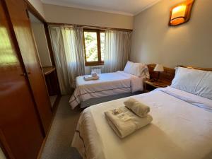 Habitación de hotel con 2 camas y toallas. en Hostería y Cabañas Quime Quipan by Nordic en San Carlos de Bariloche
