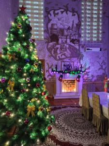 a christmas tree in a living room with a fireplace at Sulton-Sayyor in Khiva