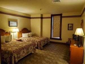 Habitación de hotel con 2 camas y ventana en Historic Bullock Hotel, en Deadwood