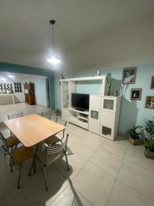 a living room with a table and a television at Casa Daval solo Familias in Villa Carlos Paz