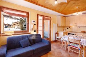 ein Wohnzimmer mit einem blauen Sofa und einem Tisch in der Unterkunft Red Casa Maurizio in Livigno