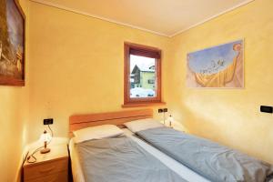 Schlafzimmer mit einem Bett und einem Fenster in der Unterkunft Red Casa Maurizio in Livigno