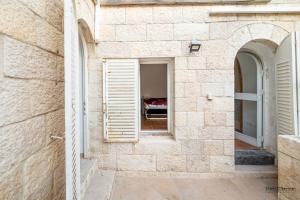 uma janela numa parede de pedra com uma cama num quarto em Temple mount view em Jerusalém