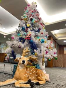Jung Shin Hotel في تشونغلي: شجرة عيد الميلاد مع اثنين من الحيوانات المحشوة بجوار شجرة عيد الميلاد