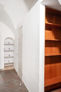 a hallway with white walls and wooden shelves at Temple mount view in Yerushalayim