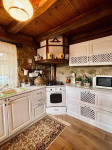 a kitchen with white appliances and a wooden ceiling at Little Stone Villa in Kírki