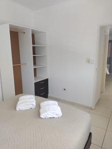 um quarto com duas toalhas brancas numa cama em Mali Departamento em Mendoza