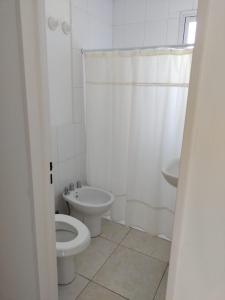 Baño blanco con aseo y lavamanos en Mali Departamento en Mendoza
