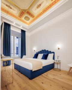 a bedroom with a large bed with a blue headboard at SM Mellini Relais B&B in Rome