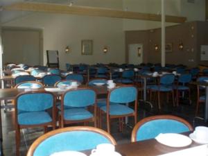 a room filled with tables and blue chairs at Vip Mullsjö in Mullsjö