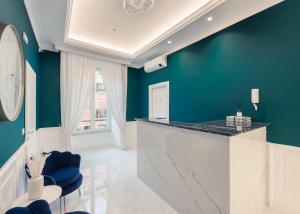 a kitchen with blue walls and a counter with blue chairs at SM Mellini Relais B&B in Rome