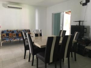 a dining room with a table and black chairs at CASA PALMA REAL PLAYACAR in Playa del Carmen