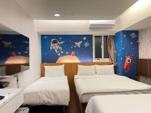 a room with two beds and an astronaut mural at Jung Shin Hotel in Zhongli