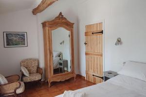 - une chambre avec un lit, un miroir et une chaise dans l'établissement Gite Amandier, Ferme Bel Air, Riez, à Riez