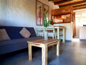 a living room with a blue couch and a table at Posada del Corumbá in La Paloma