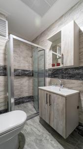 a bathroom with a toilet and a sink and a shower at KUMBAĞ ŞEHRİ SARAY APART OTEL in Tekirdag