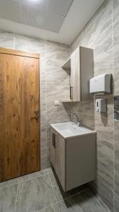 a bathroom with a sink and a wooden door at KUMBAĞ ŞEHRİ SARAY APART OTEL in Tekirdag +58 photos