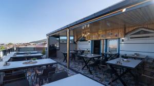 a restaurant with tables and chairs on a balcony at KUMBAĞ ŞEHRİ SARAY APART OTEL in Tekirdag