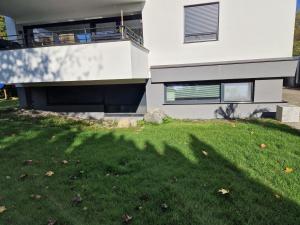 une maison avec une pelouse verte devant dans l'établissement Ferienwohnung am Schloß, à Friedrichshafen