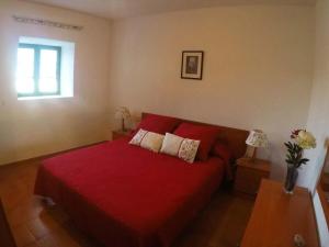 Villa Laura Guatiza في Guatiza: غرفة نوم بسرير احمر ونافذة