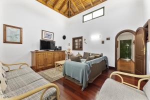 a living room with a couch and a tv at Villa Laura Guatiza in Guatiza
