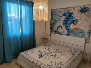 a bedroom with a bed with blue curtains and a chandelier at Villa Colapesce in Marzamemi