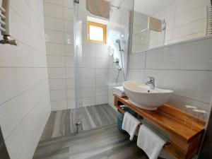 a white bathroom with a sink and a shower at PLITVICE ETNO HOUSE II in Jezerce