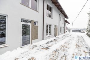 uma rua coberta de neve em frente a uma casa em Apartamenty na Górce em Olsztyn