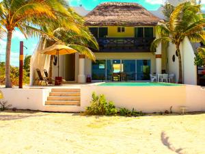 une maison sur la plage avec une piscine et des palmiers dans l'établissement Hidra luxurious accommodation, à San Benito