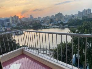 d'un balcon avec vue sur la rivière et les bâtiments. dans l'établissement Nile View 2-Bed Apartment in Zamalek Cairo, au Caire
